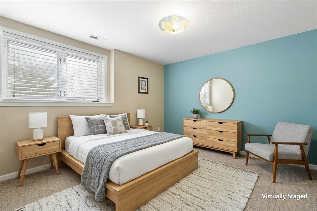 Virtually staged bedroom with a wood platform bed, turquoise accent wall, round mirror, and large window.