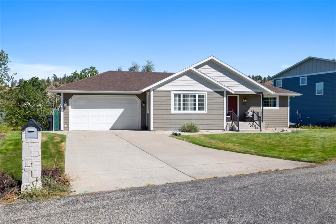 Single-story taupe home with a front gable, two-car garage, and wide concrete driveway.