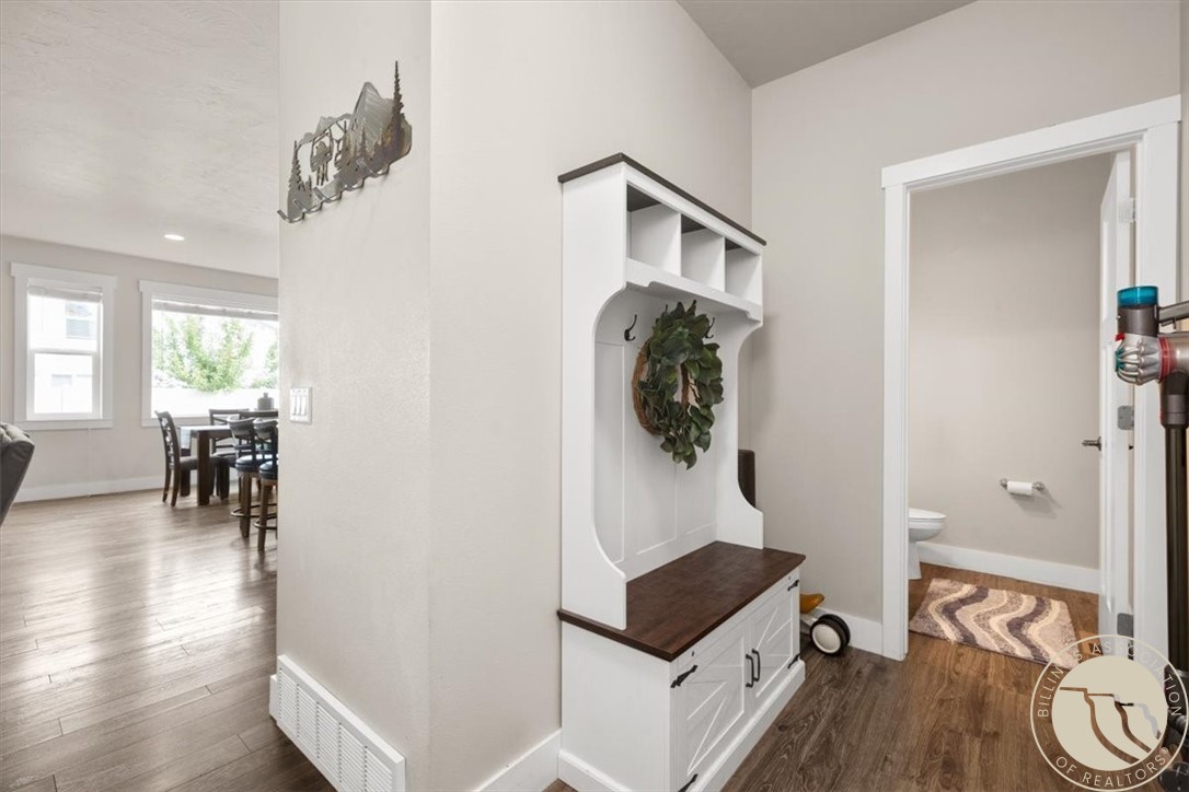 Entry hall with a built-in white bench and dark wood seat beside a half bathroom.