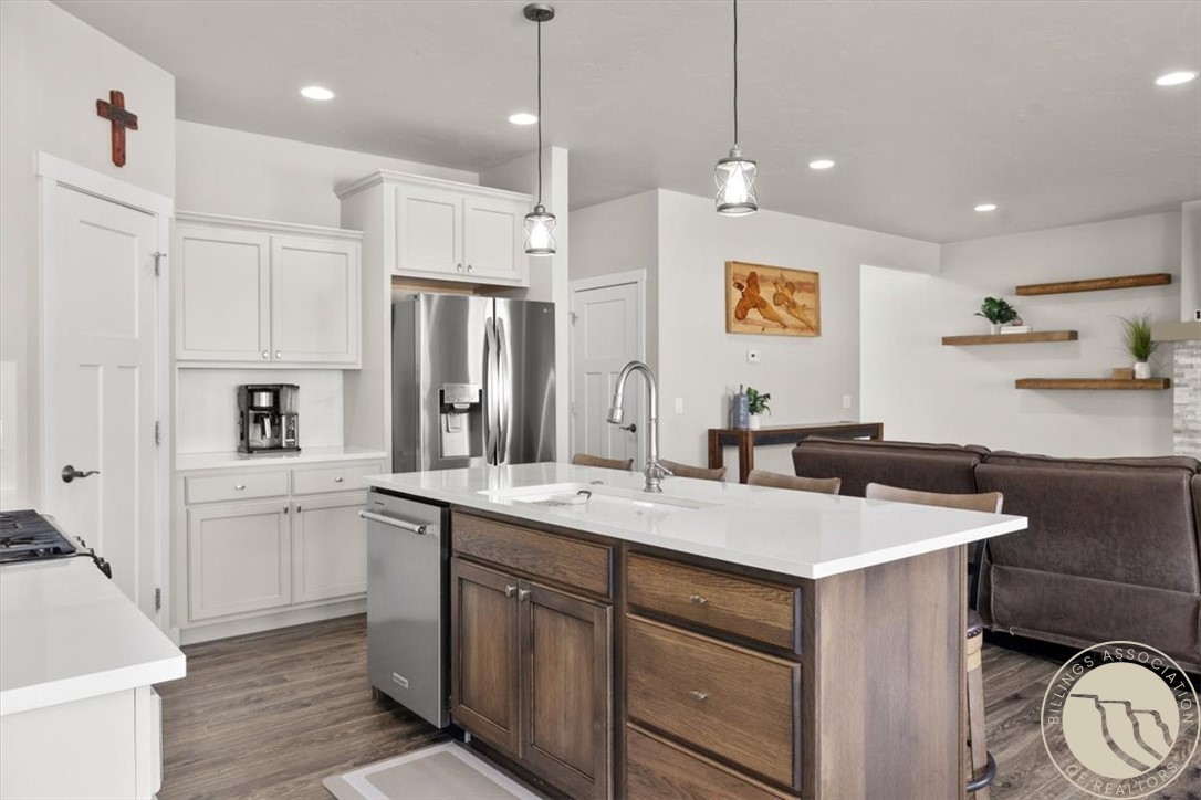Open-concept kitchen with a large wood island, white counters, and stainless steel appliances.