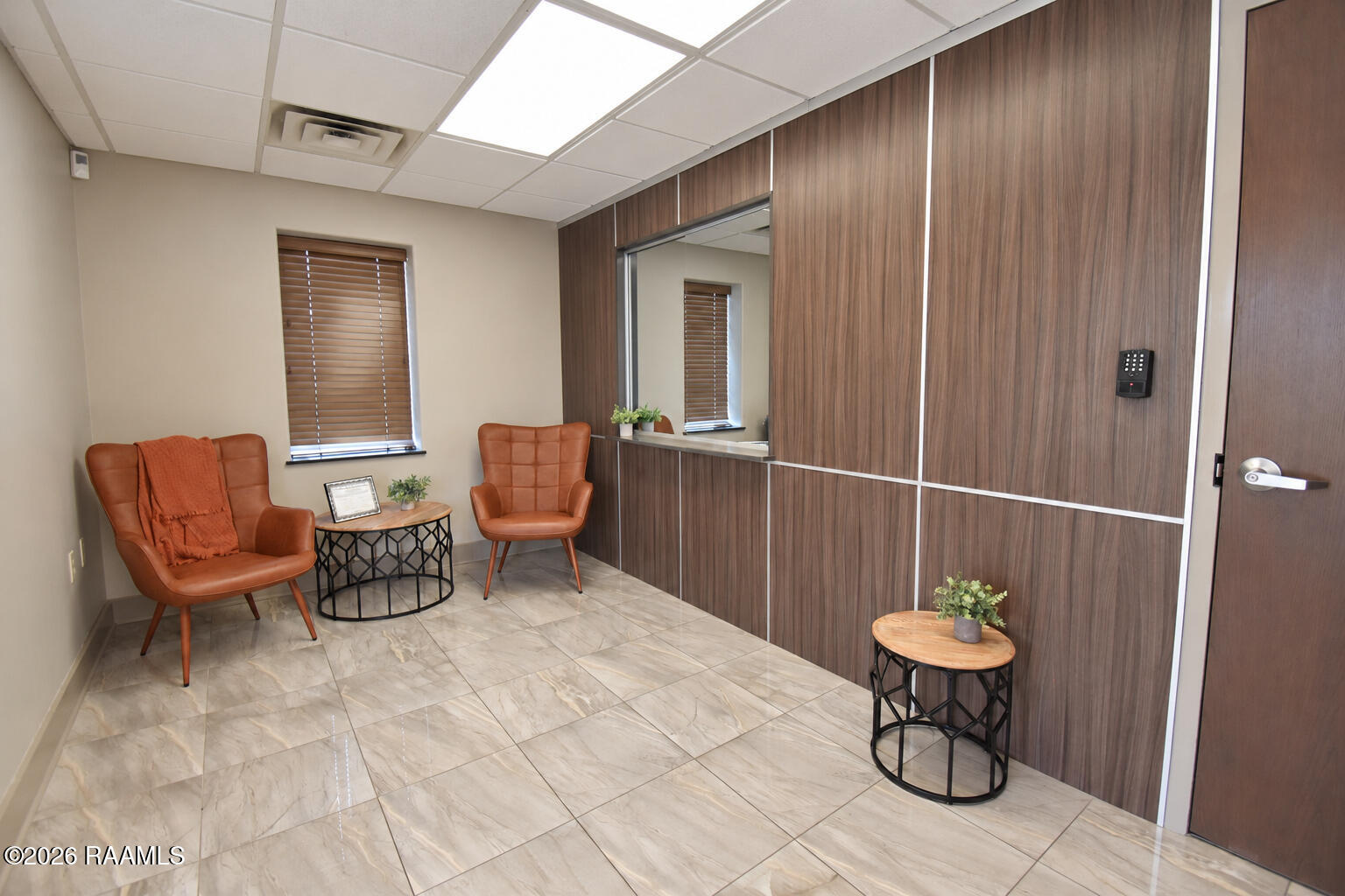Office waiting area with two rust-colored leather chairs and a wood-paneled wall.
