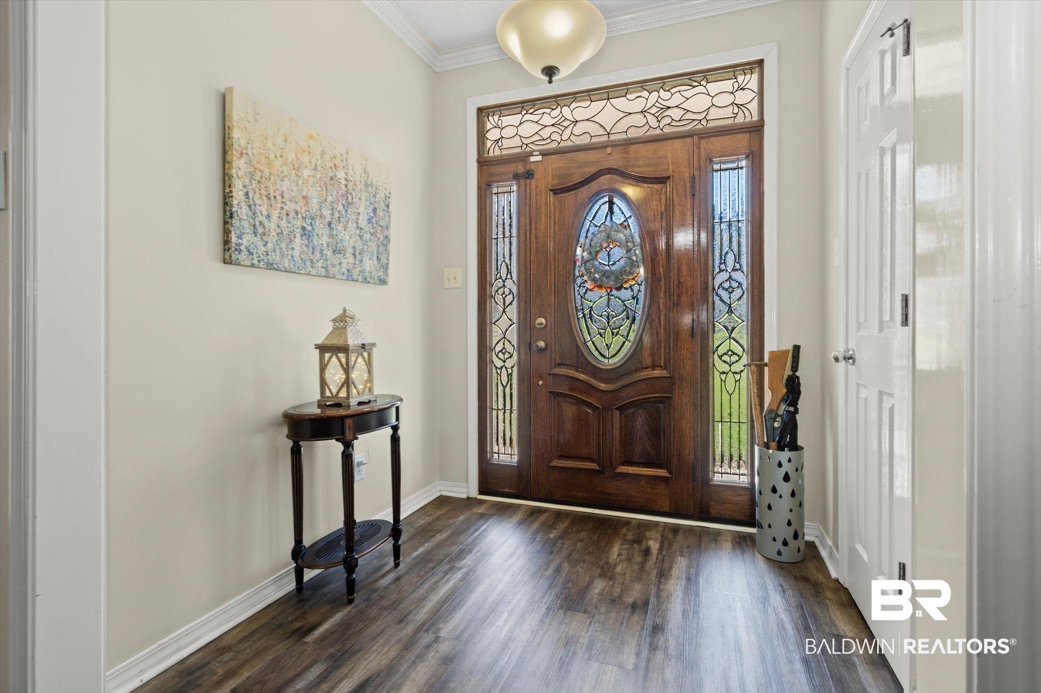 Entry foyer with a carved wood front door and ornate stained-glass panels.