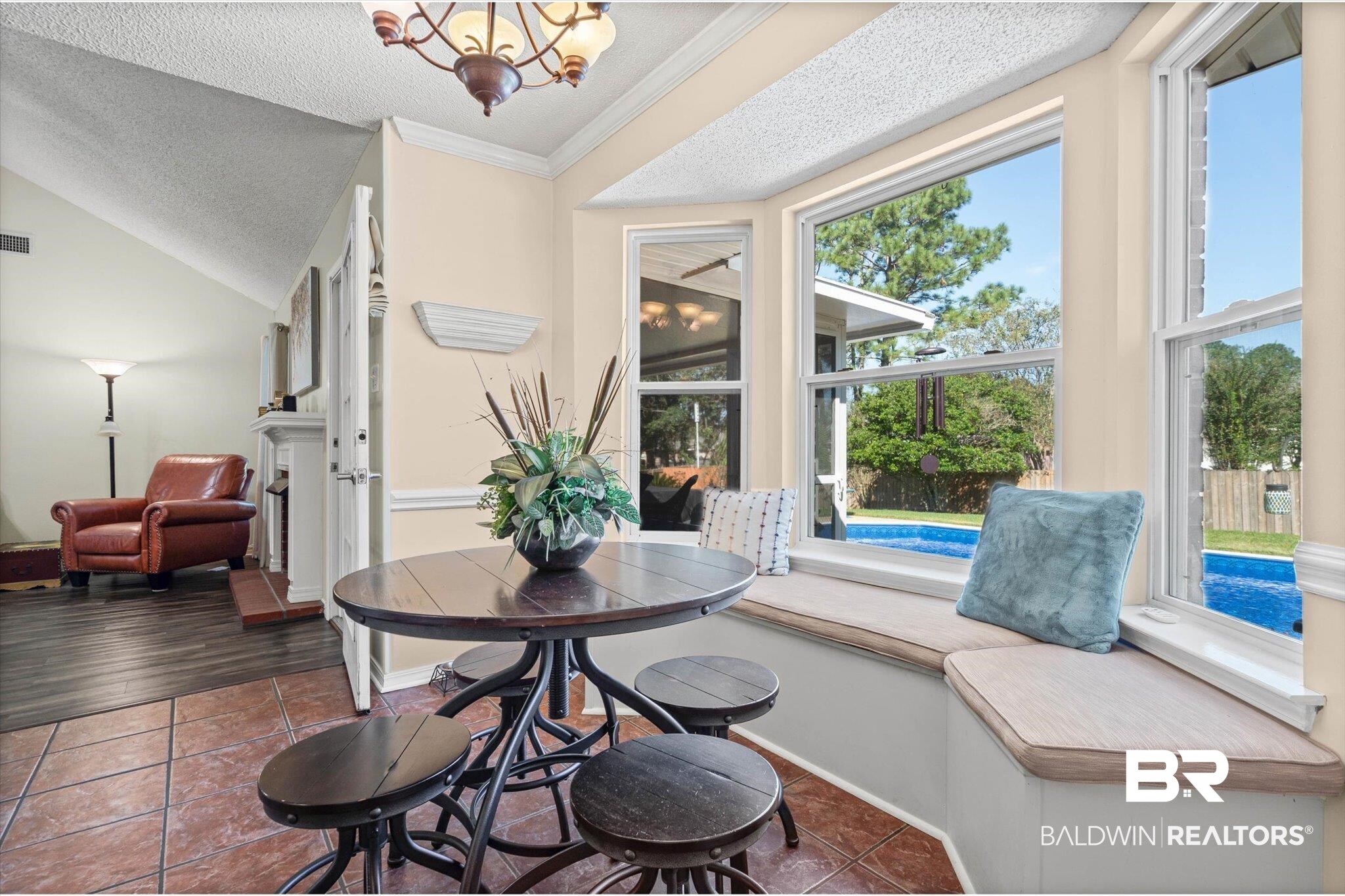 Breakfast nook with built-in window seating overlooking a swimming pool.
