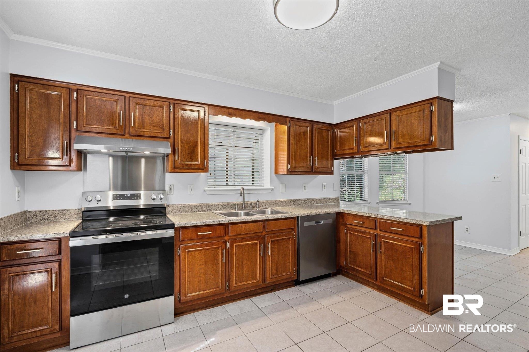Kitchen with dark wood cabinets, granite countertops, and stainless steel appliances.