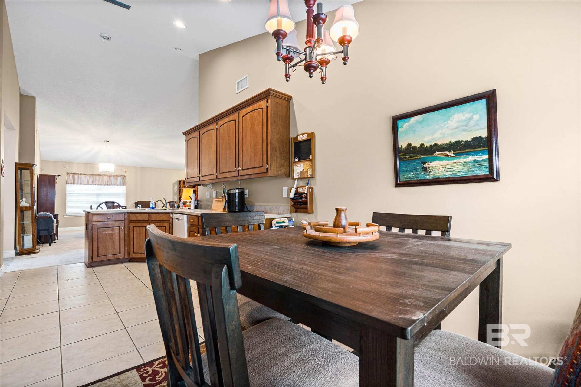 Dining area with a large dark wood table beside a warm wood kitchen.