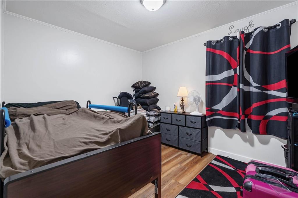 Bedroom with a dark wood bed, patterned curtains, and a black dresser.