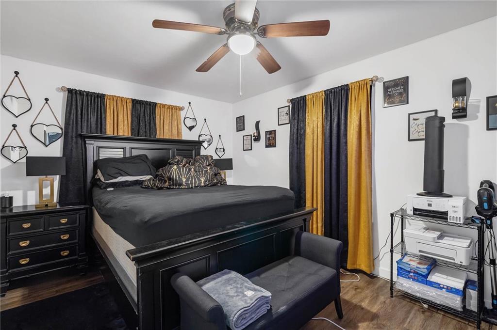 Bedroom with a large black bed, gray bench, and black-and-gold curtains.