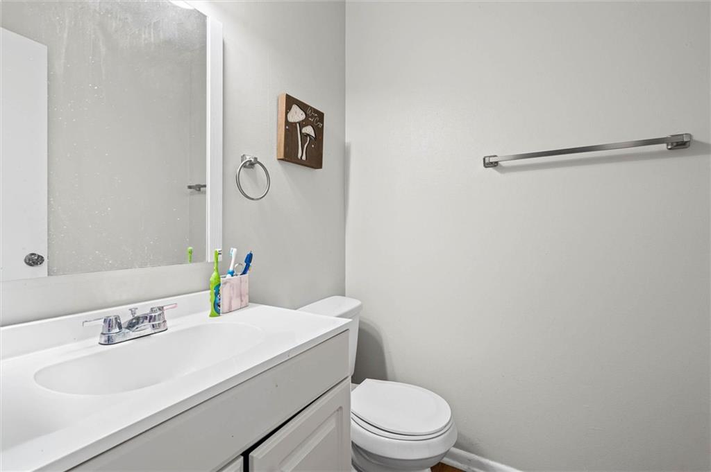Bathroom with a white vanity, sink, and toilet.
