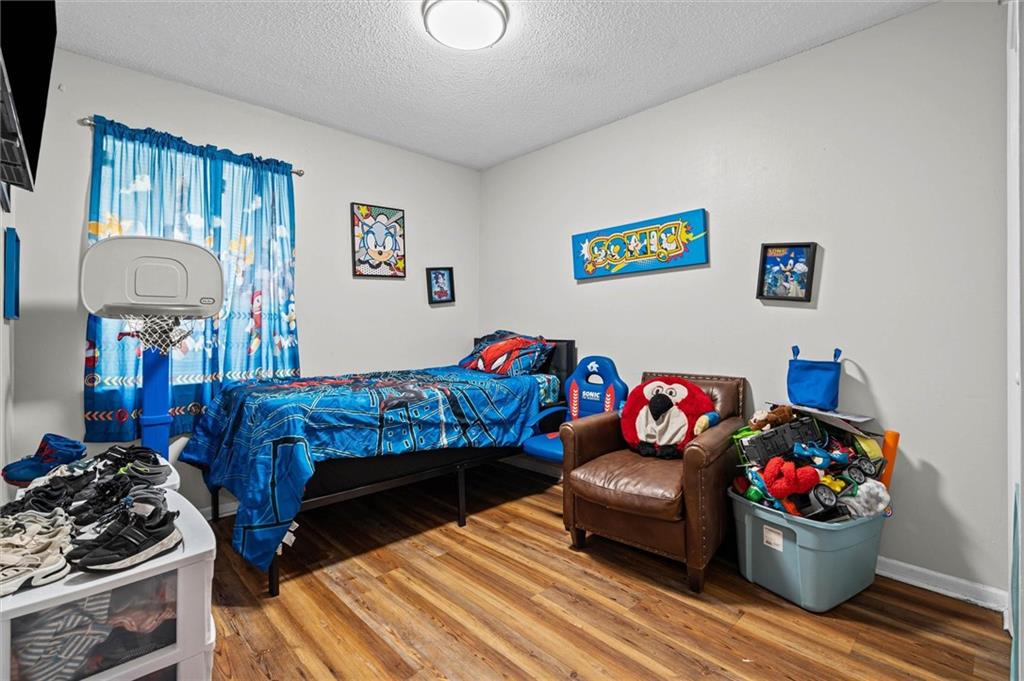 Bedroom with blue Sonic bedding, a small basketball hoop, and a brown armchair.