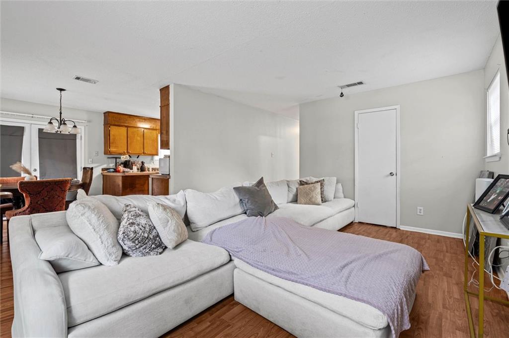 Living room with a large white sectional sofa and chaise beside an open kitchen and dining area.