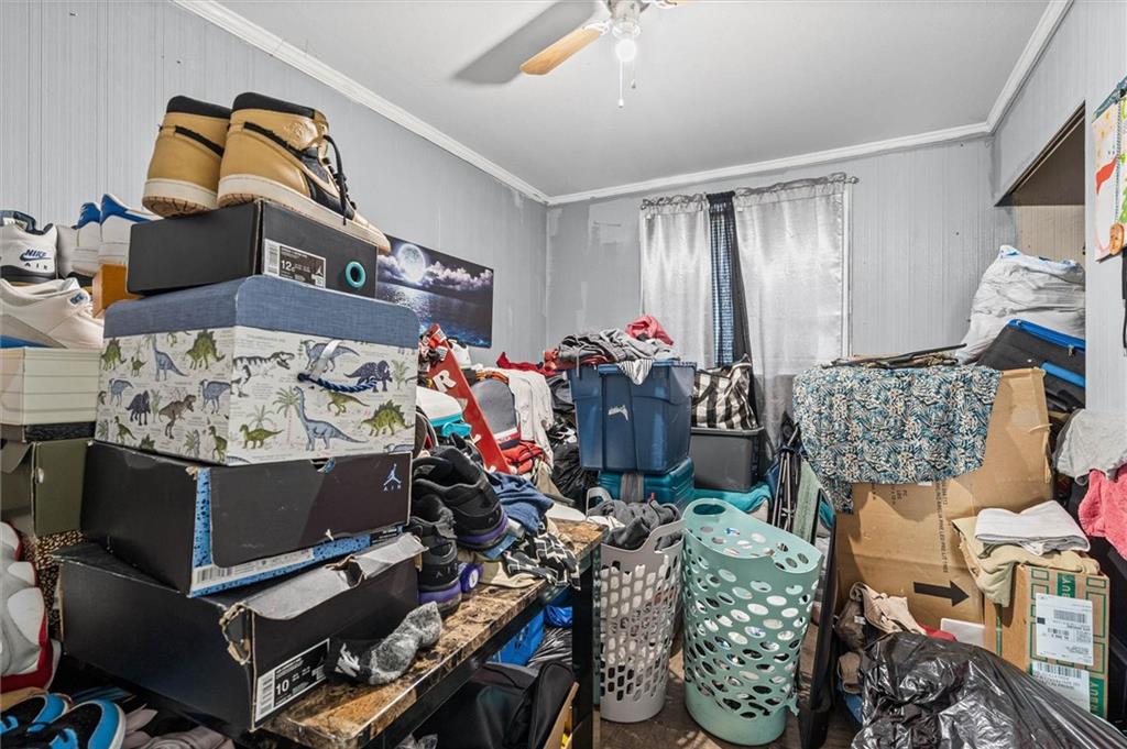 Cluttered storage room with stacked shoe boxes, plastic bins, laundry, and bags.