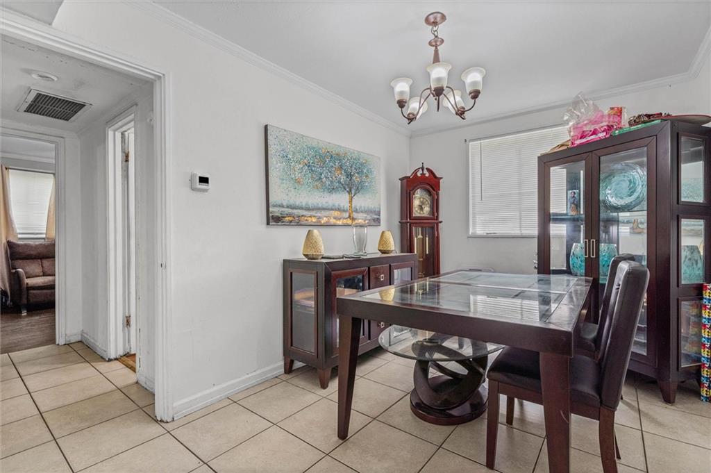 Dining room with a glass-top table, dark wood china cabinet, and grandfather clock.