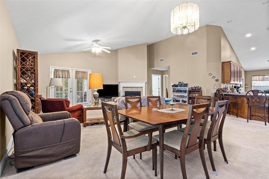 Open-plan dining and living room with a large wooden table and fireplace.