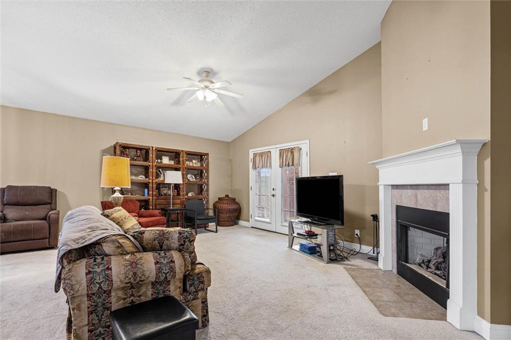 Living room with a white fireplace, built-in bookshelves, and French doors.