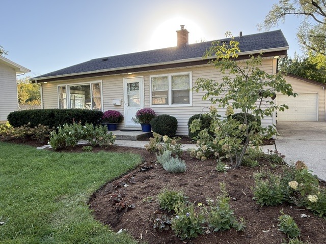 Single-story home with an attached garage and landscaped front garden.