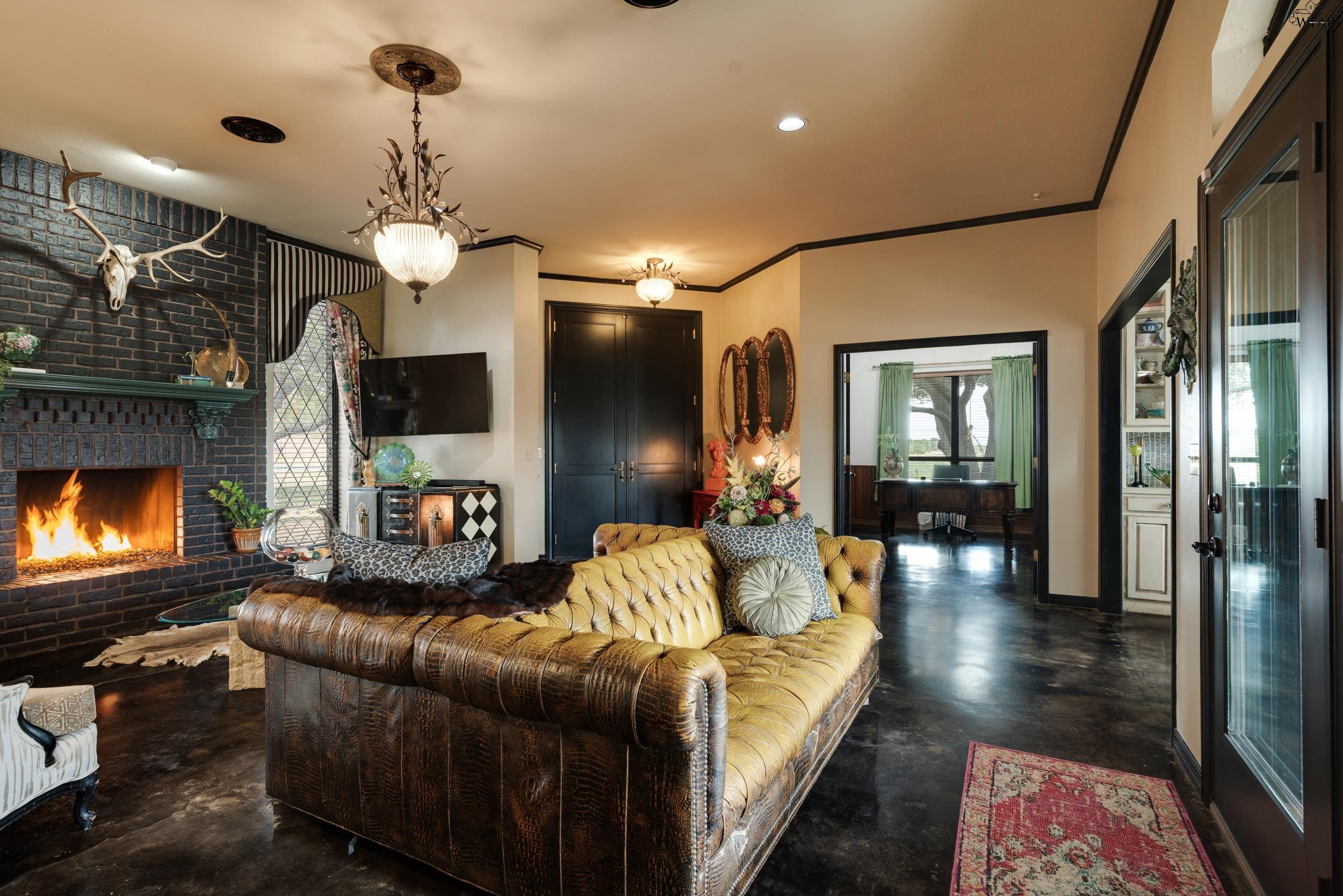 Furnished living room with a brick fireplace, mounted antlers, and a tufted leather sectional.
