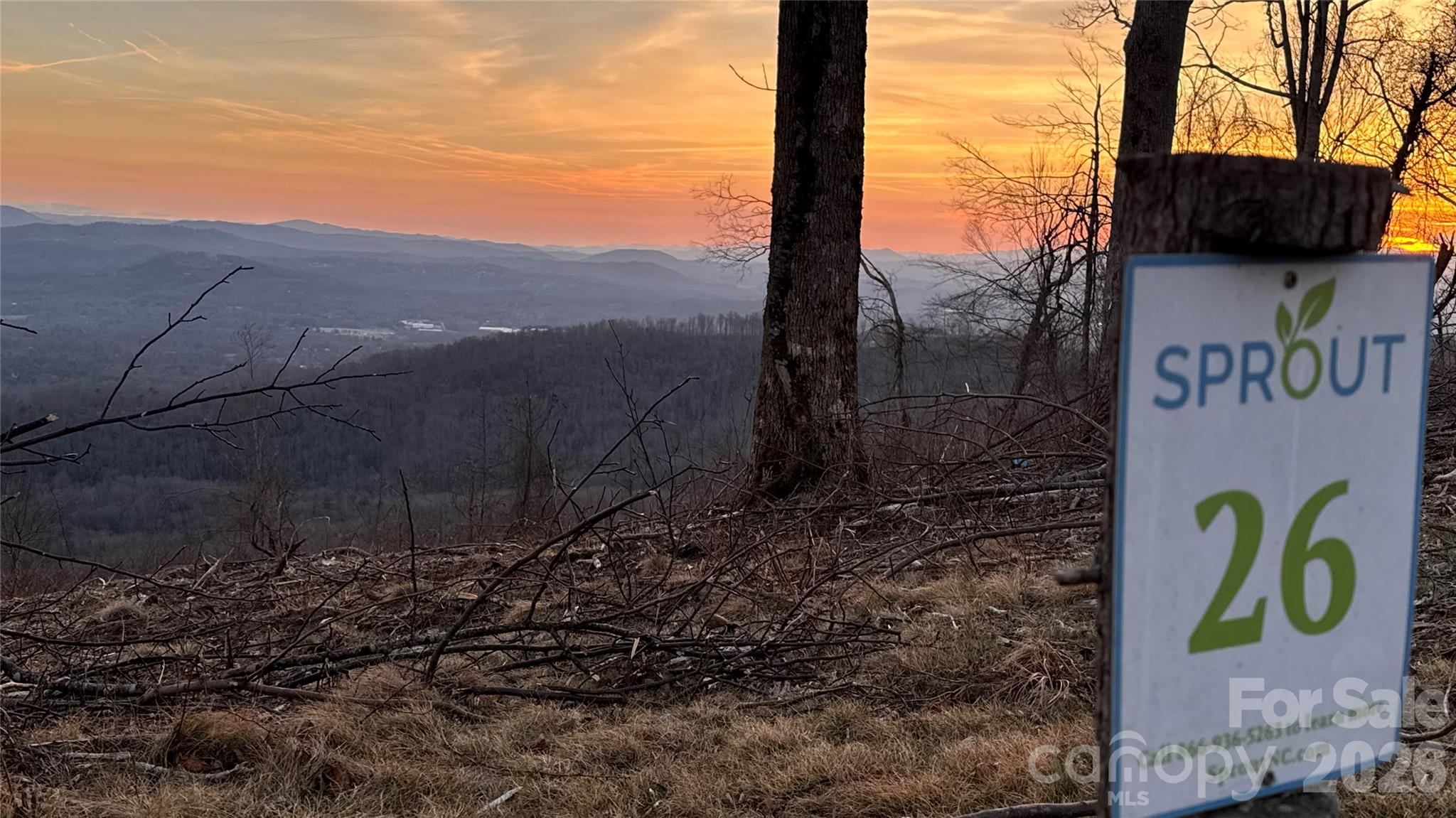 Mountain-view land at sunset, with a Sprout sign marked 26 in the foreground.