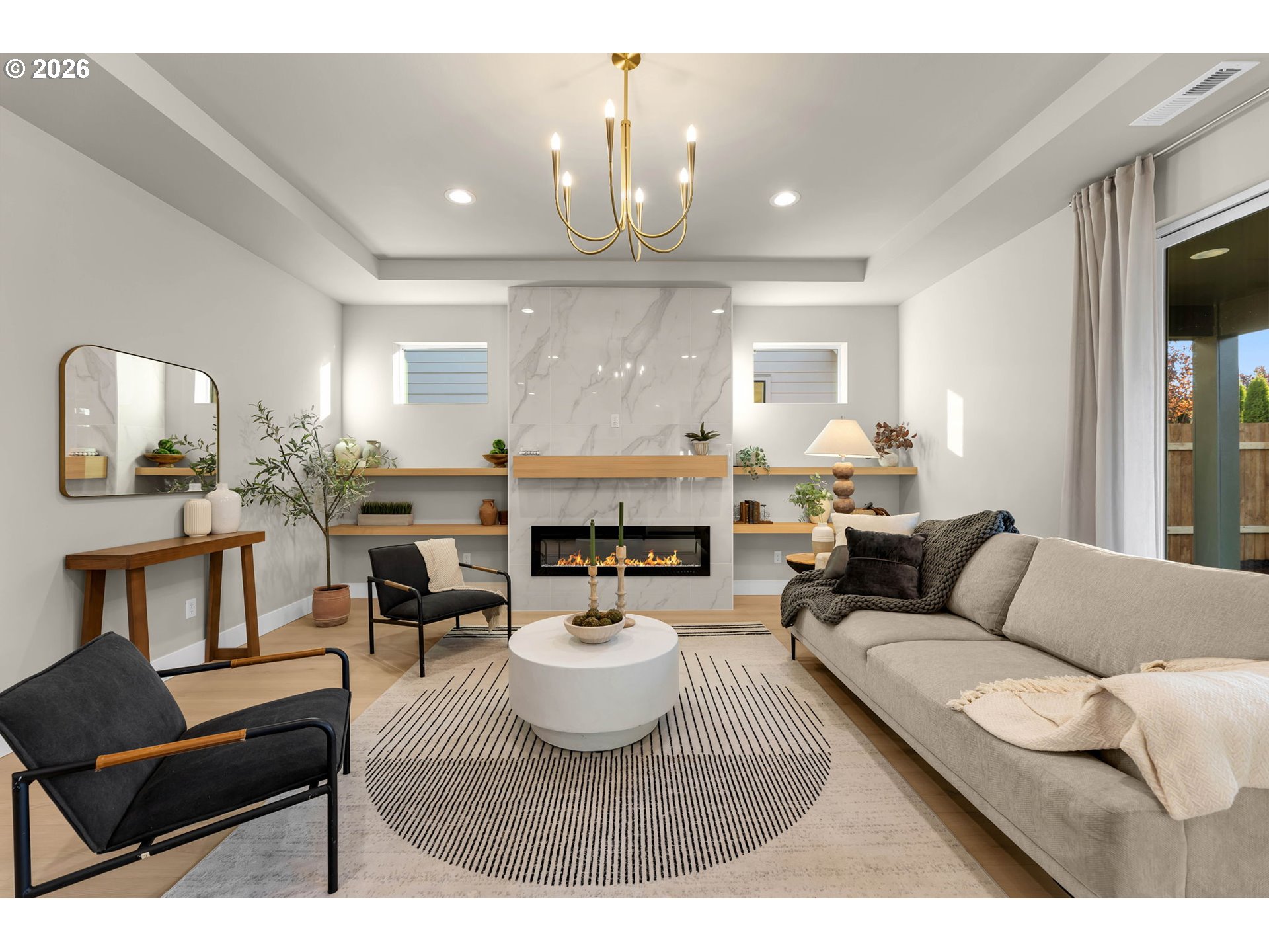 Living room with a marble fireplace, built-in wood shelves, and neutral seating.