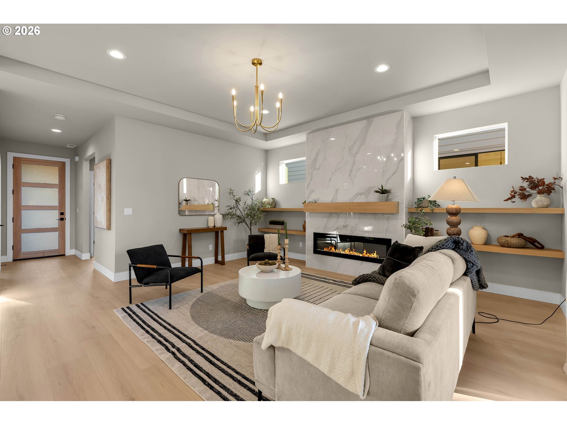 Staged living room with a marble fireplace, linear gas fire, and cream sectional sofa.