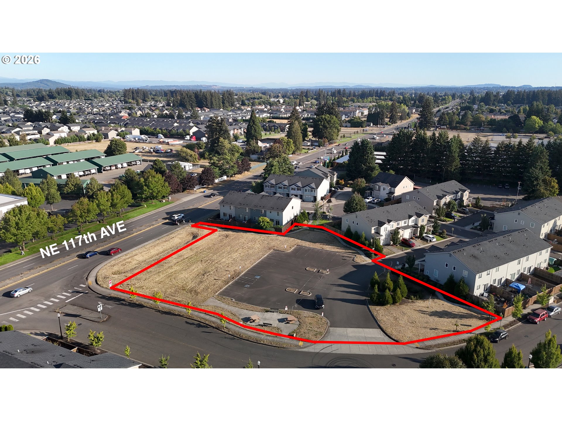 Vacant land outlined in red beside NE 117th Avenue, surrounded by homes and roads.