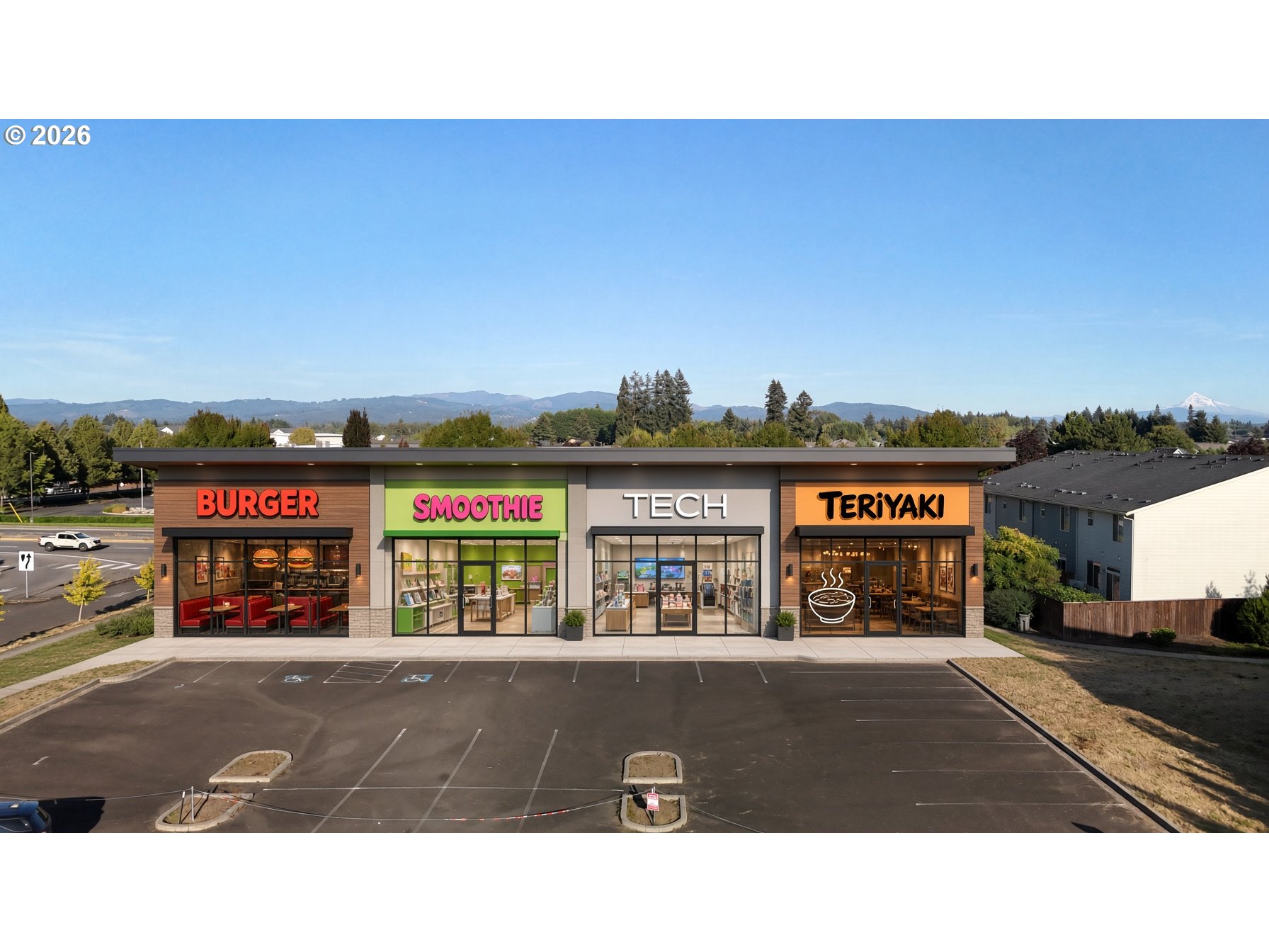 Commercial strip center with four storefronts and a broad parking lot, backed by distant hills and a snowy peak.
