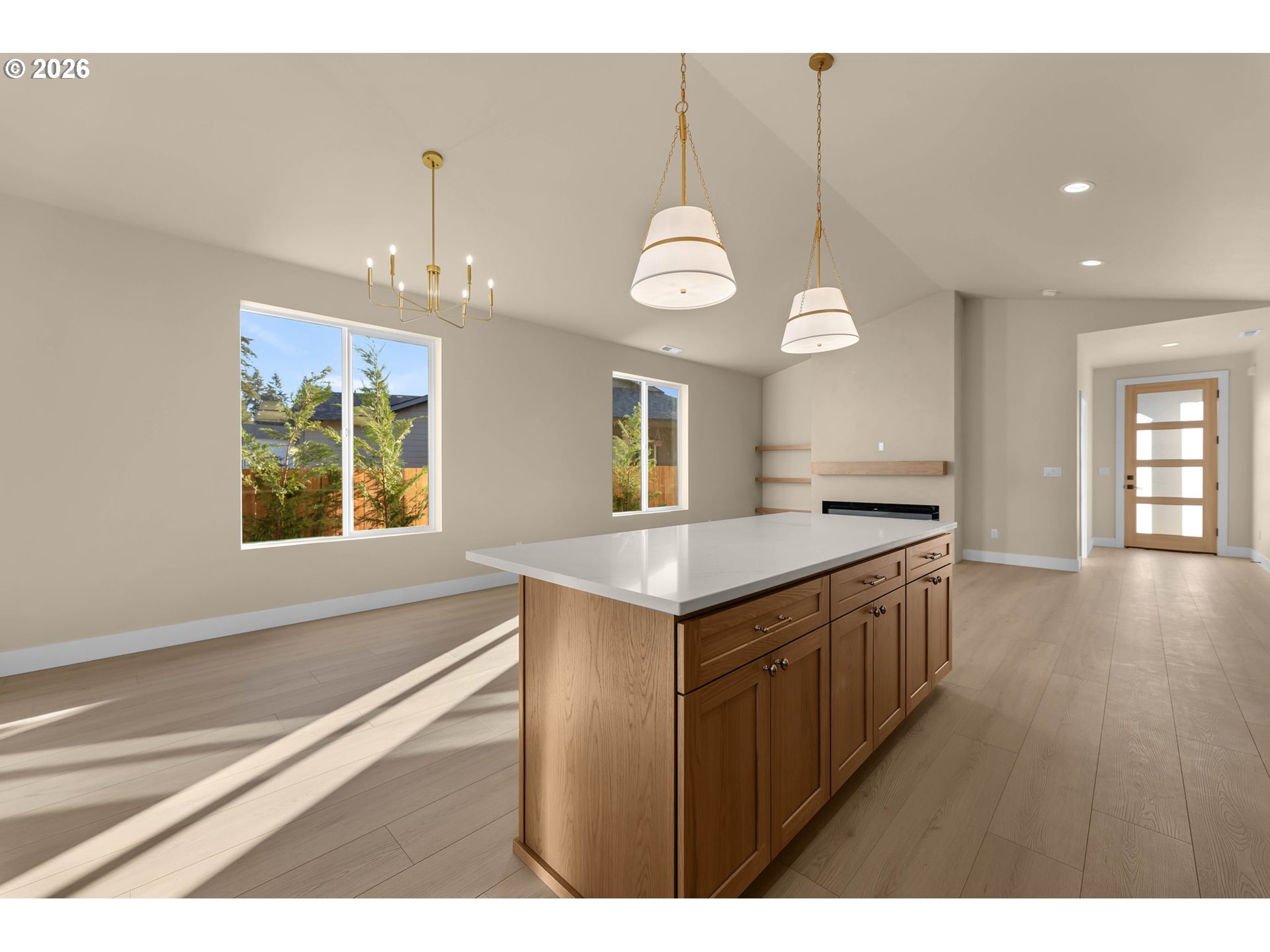 Kitchen with a large wood-cabinet island, pendant lights, and a modern fireplace.