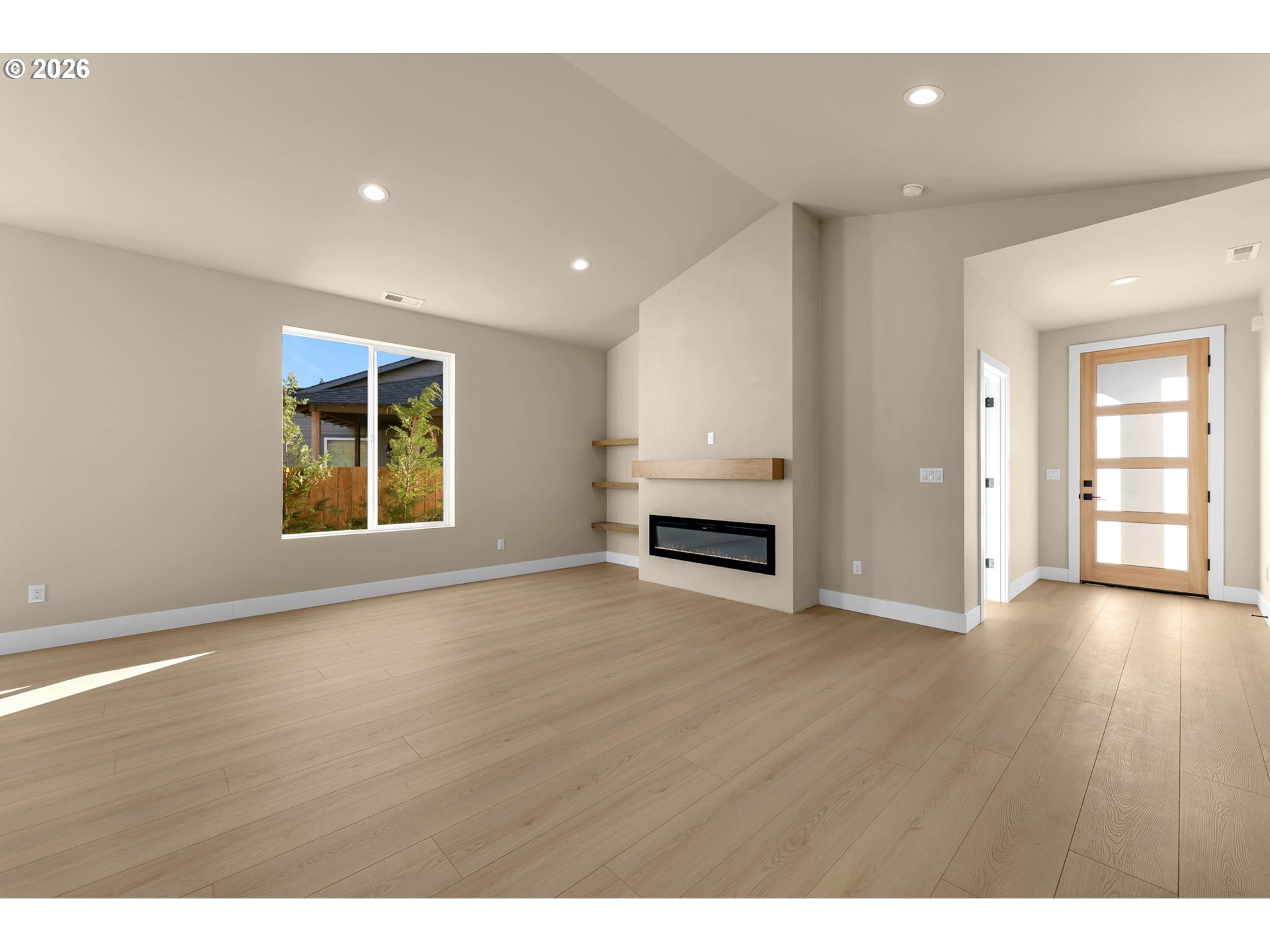Unfurnished living room with a linear fireplace, built-in shelves, and light wood flooring.