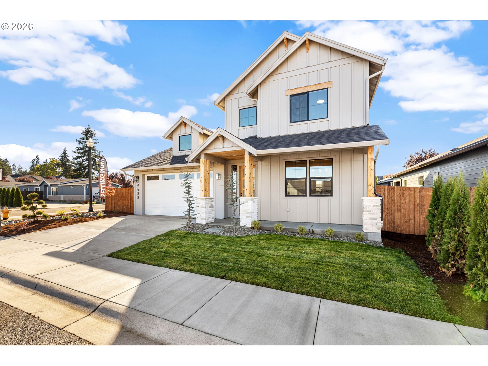 Two-story house with an attached garage, covered porch, and neatly landscaped front lawn.