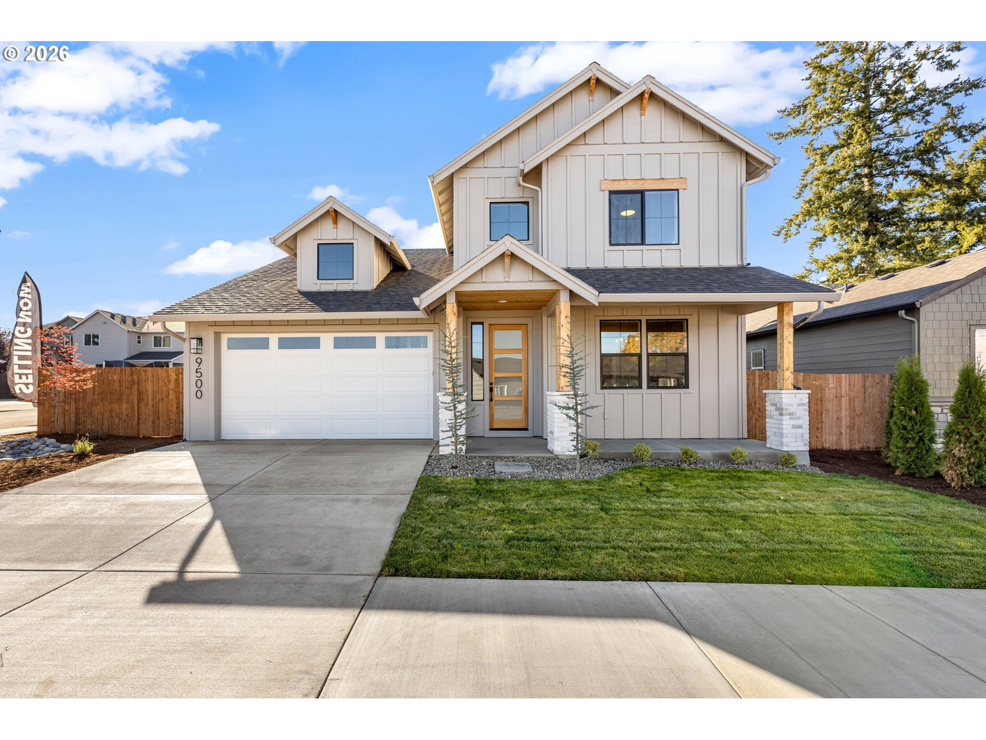 Two-story house with a double garage, covered entry, and broad concrete driveway.