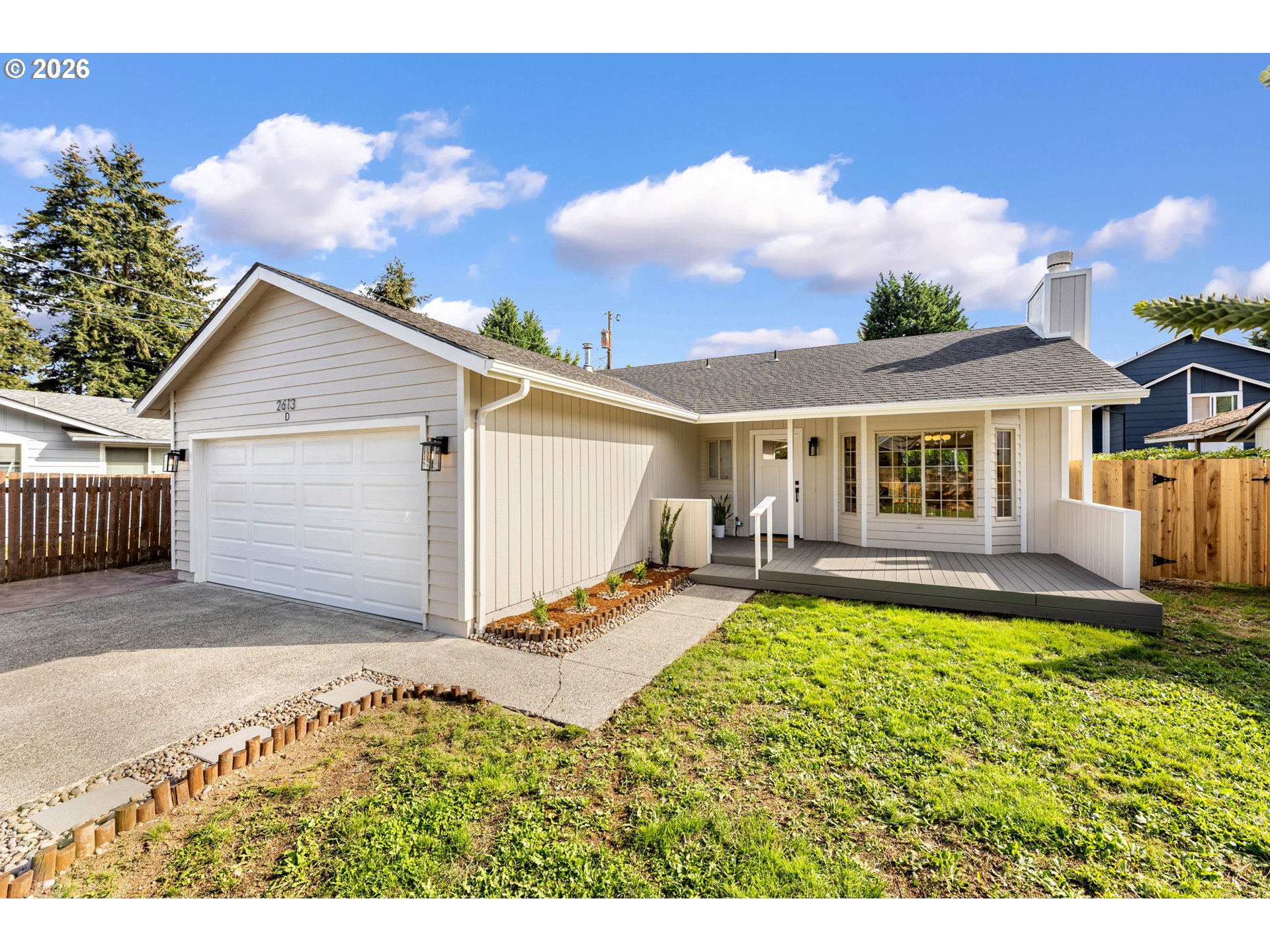 Single-story home with a double garage, covered porch, and raised front deck.
