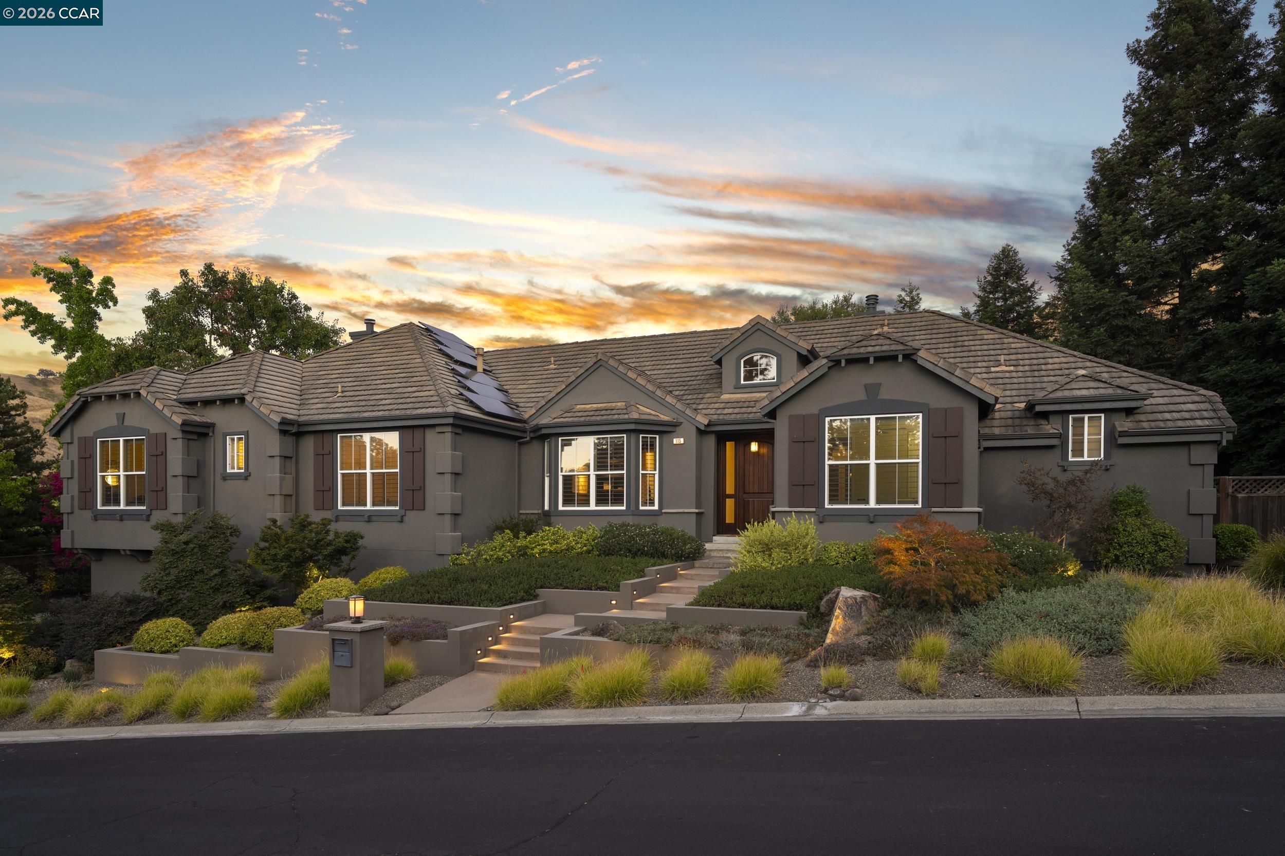 Home at 115 Byerley Ct with tiled roof, solar panels, and landscaped entry at dusk.