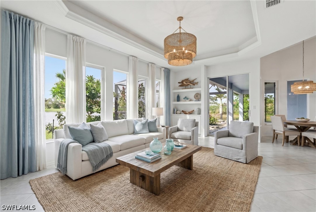 Staged living room with a white sofa, woven rug, and tall windows overlooking water.