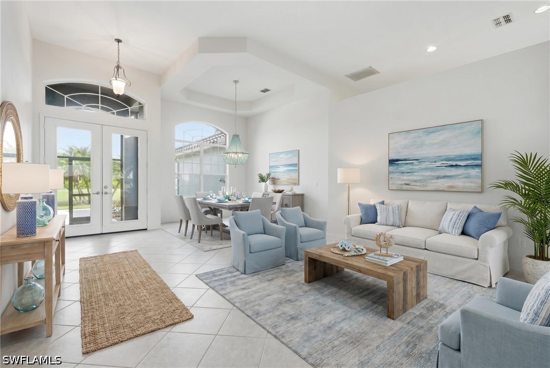 Staged living room with pale blue armchairs, a white sofa, and an adjoining dining area.