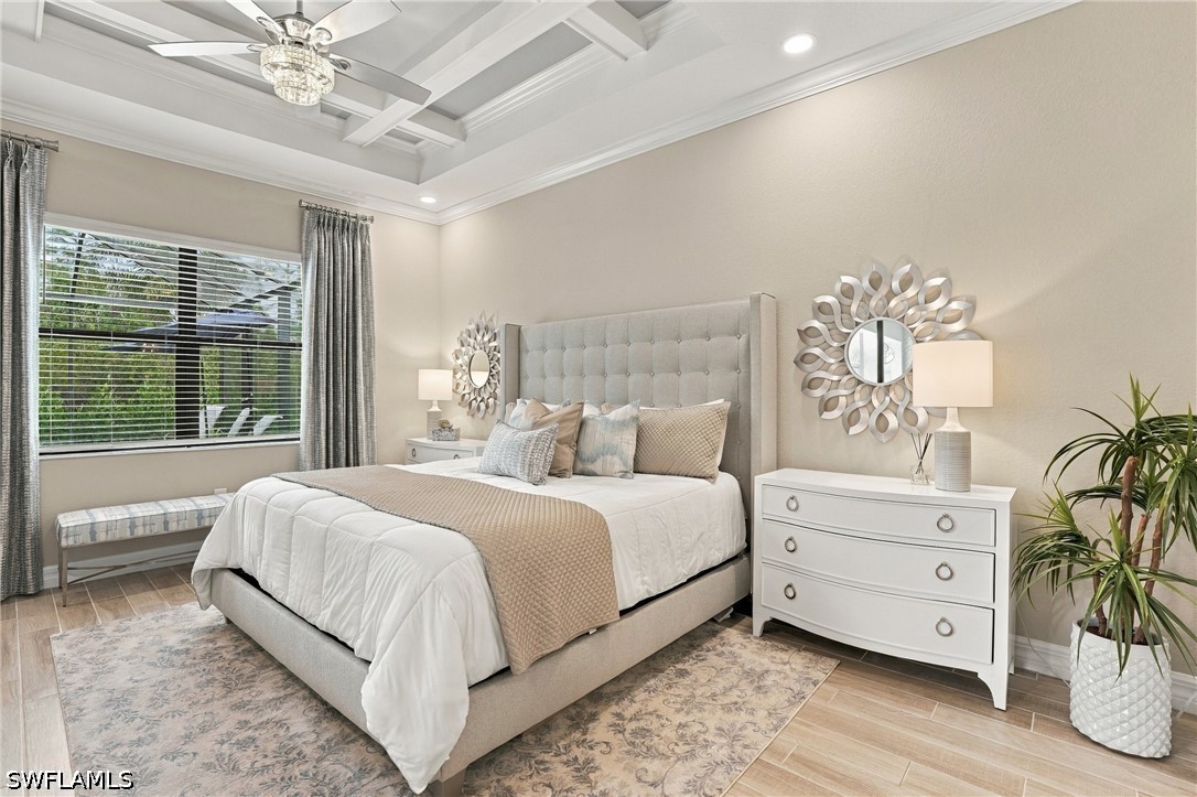 Staged bedroom with tufted bed, tray ceiling, window seat, and patterned area rug.