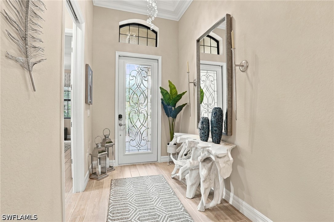 Foyer with decorative glass front door, patterned runner, and sculptural white console table.