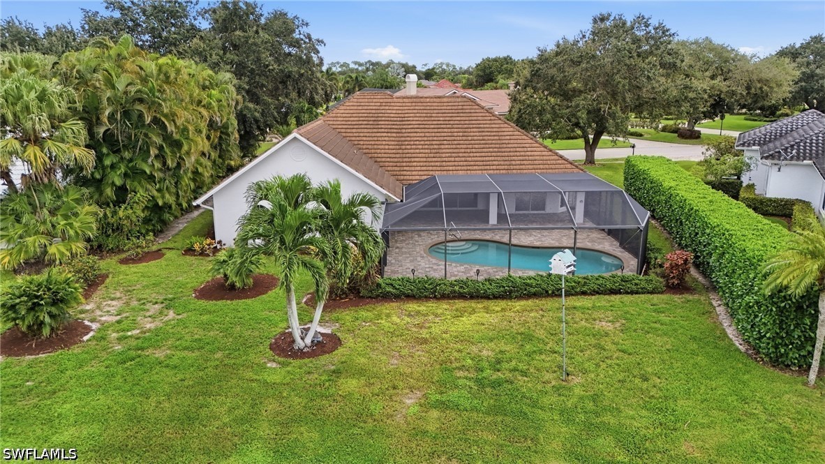 Aerial view of a home with a screened-in pool and landscaped backyard.