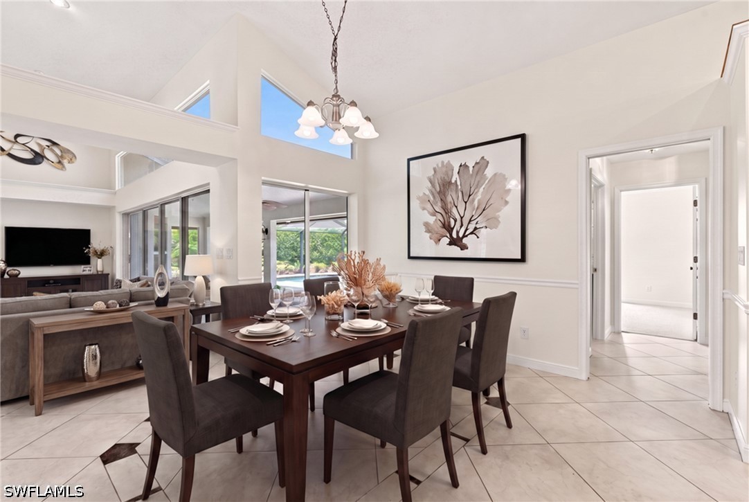 Dining area with a dark wood table, high ceilings, and sliding glass doors.