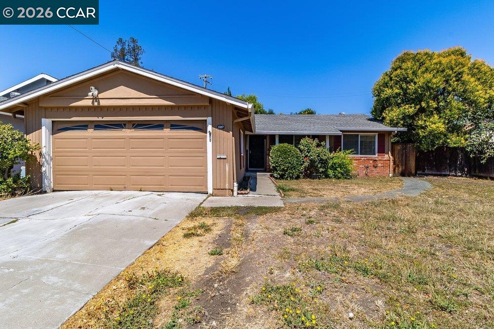 Single-story home with a two-car garage, concrete driveway, and dry front yard.