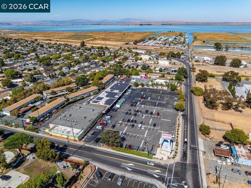 Aerial view of Bay Point, with neighborhood homes and a parking lot beside wetlands and bay waters.
