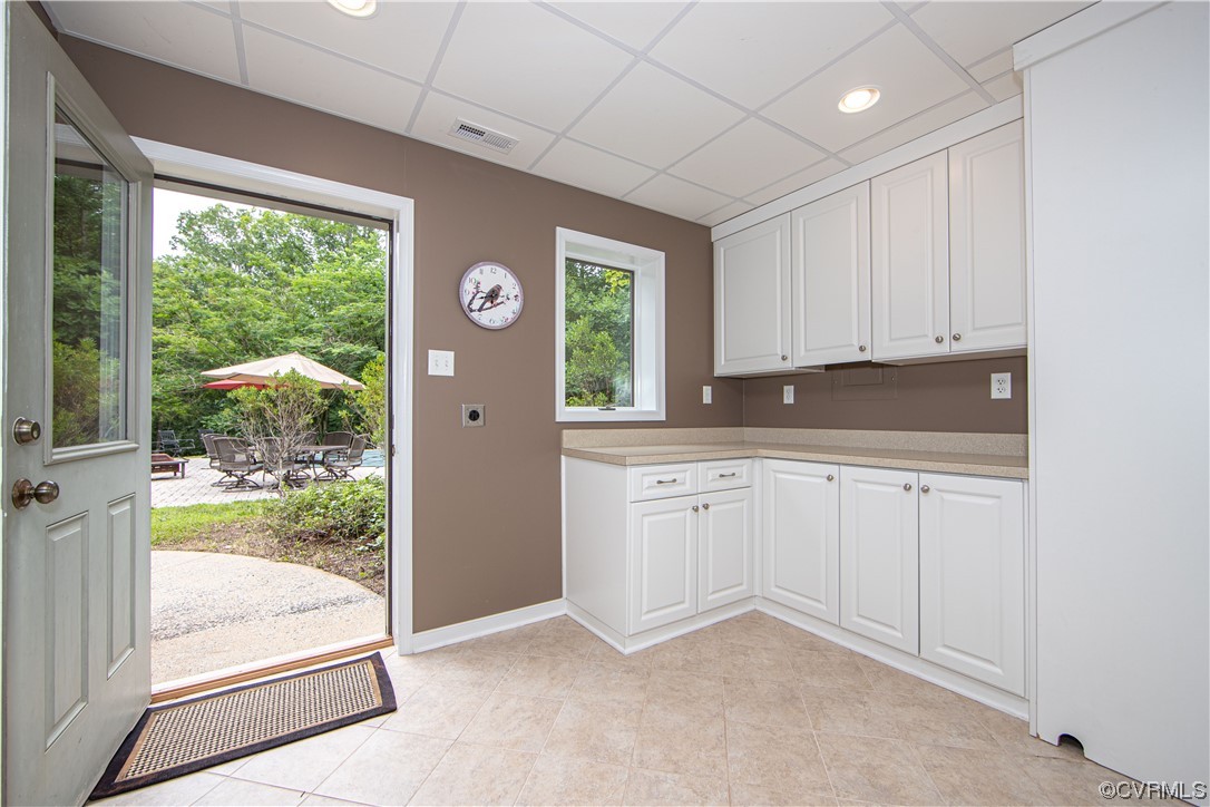 Utility room with white built-in cabinets and an open door to a patio.