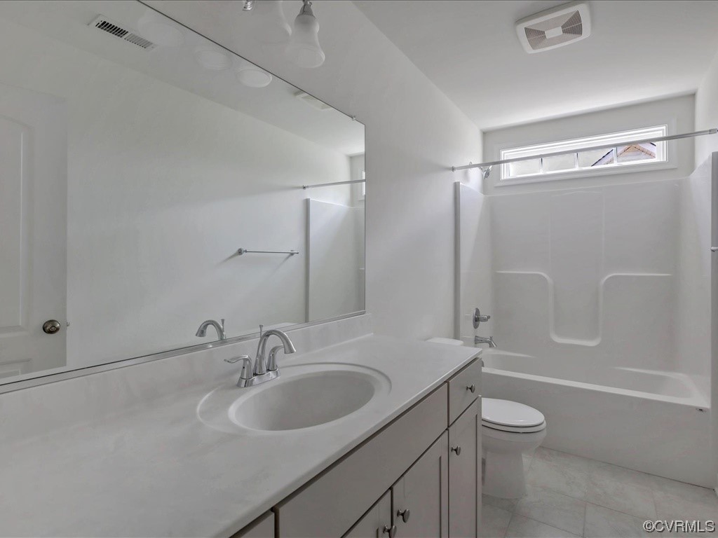 Bathroom with a long white vanity, large mirror, and tub-shower beneath a high window.