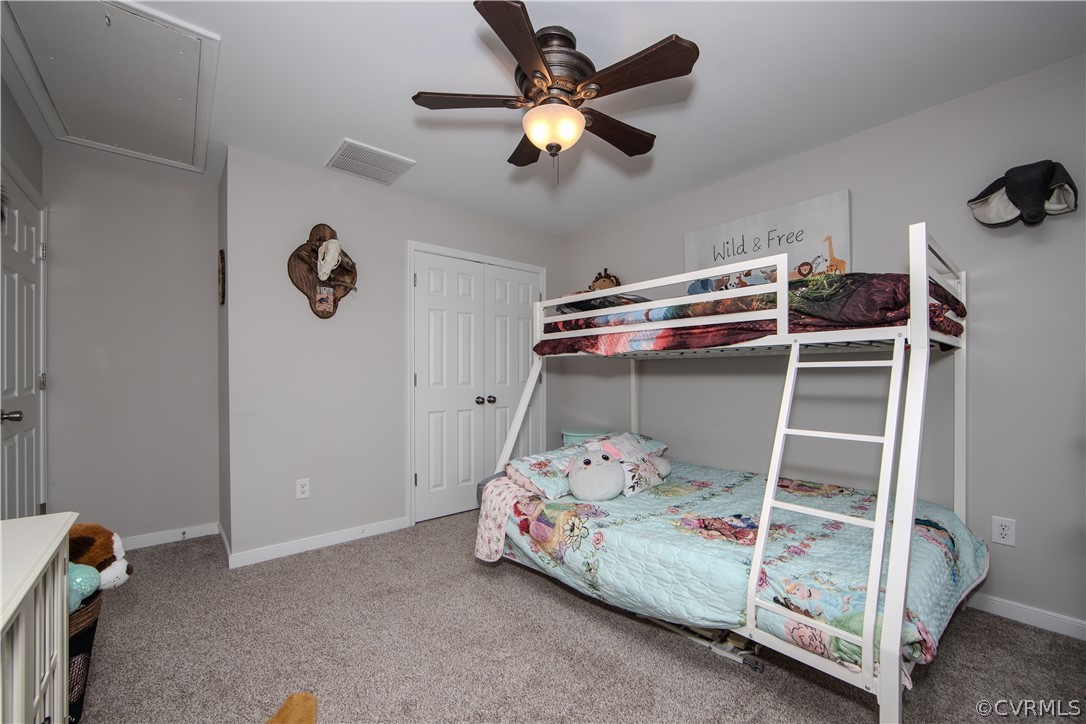 Bedroom with a floral bed beneath a white loft bunk and a ceiling fan.