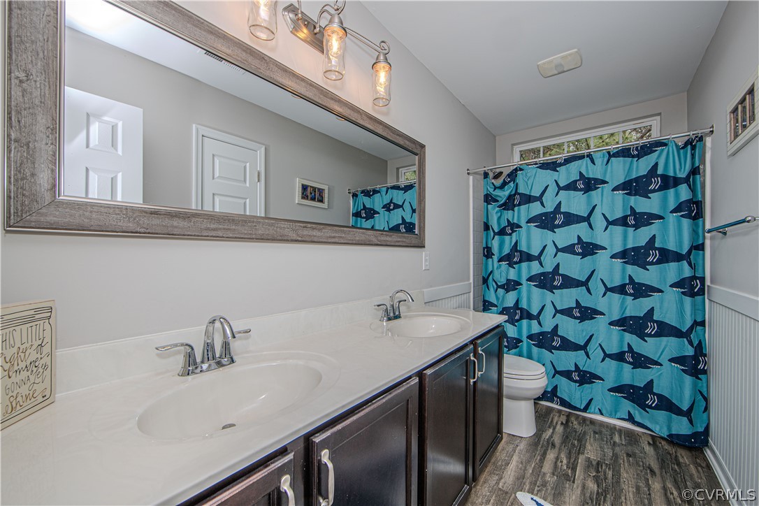 Bathroom with double vanity, large mirror, and blue shark-patterned shower curtain.
