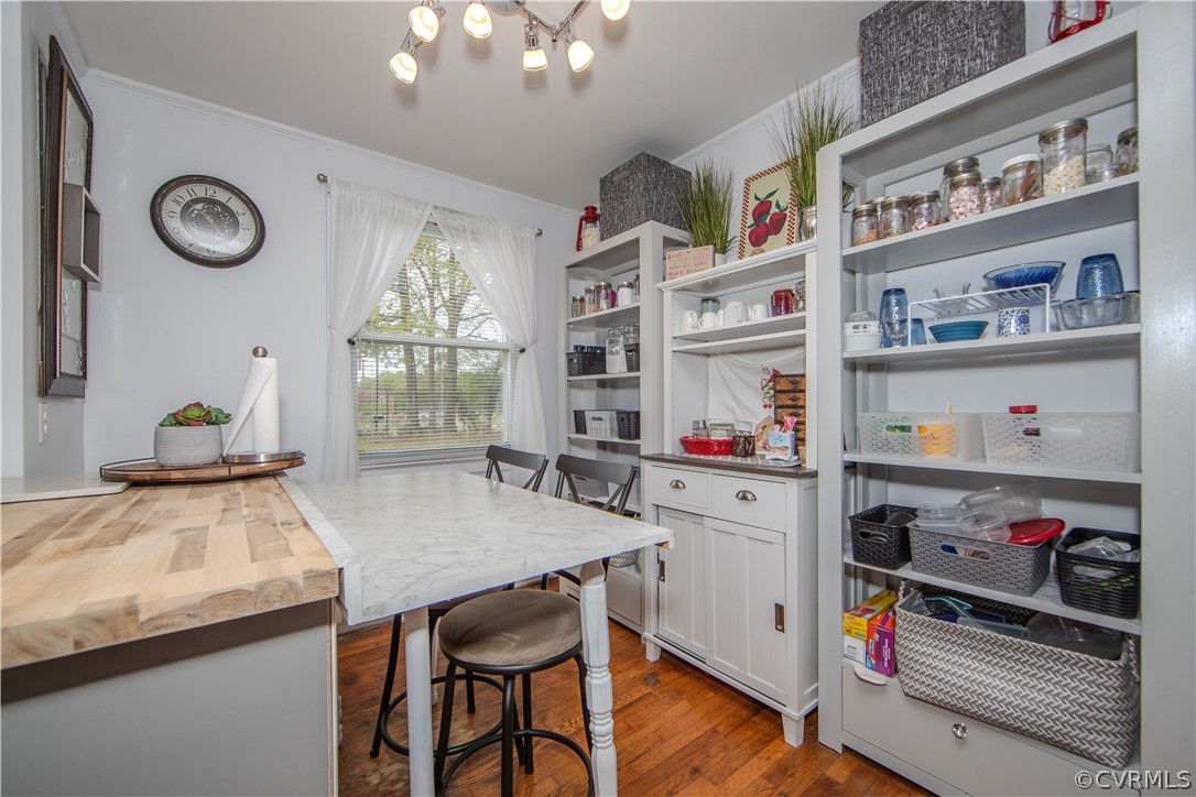 Kitchen with extensive white pantry shelving, a marble-topped island, and butcher-block counter.