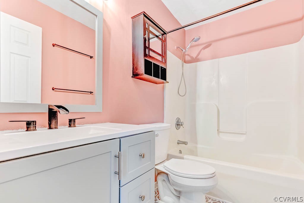 Bathroom with pink walls, a white vanity, and a tub-shower combination.