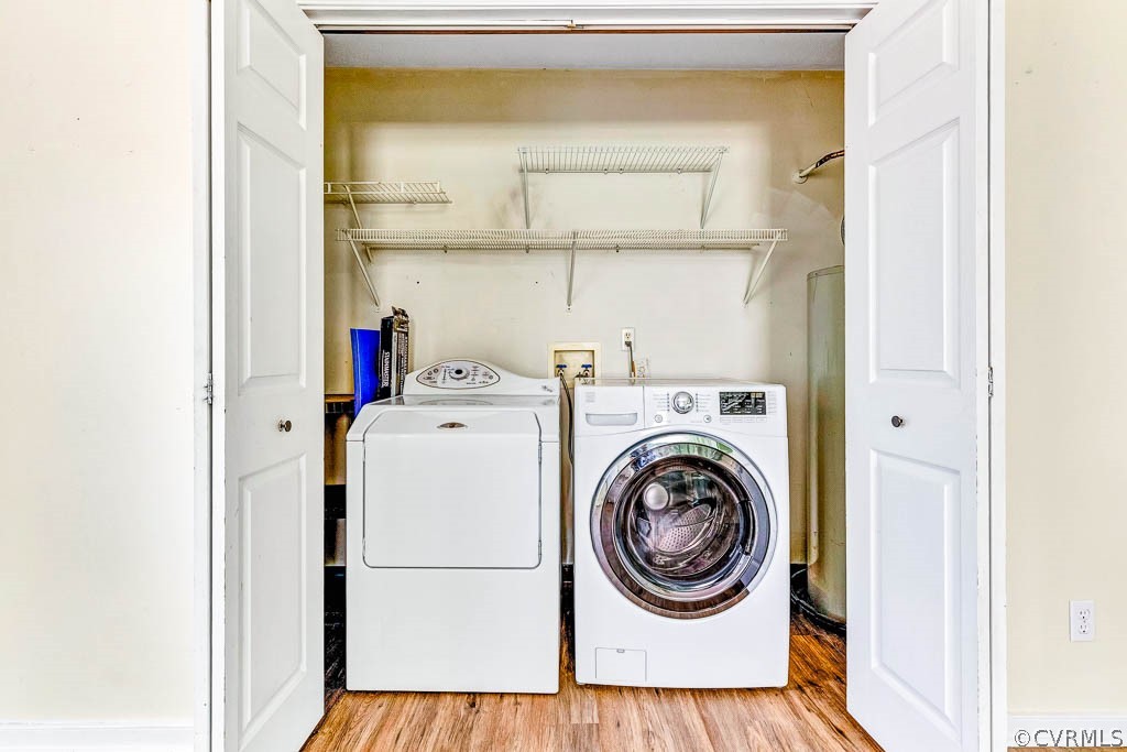 Laundry room with side-by-side washer and dryer, wire shelves, and wood-look flooring.
