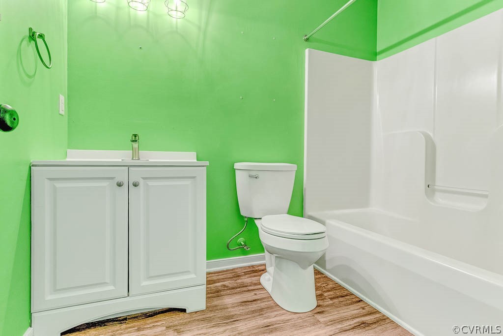 Bathroom with vivid green walls, white vanity, toilet, and tub-shower surround.