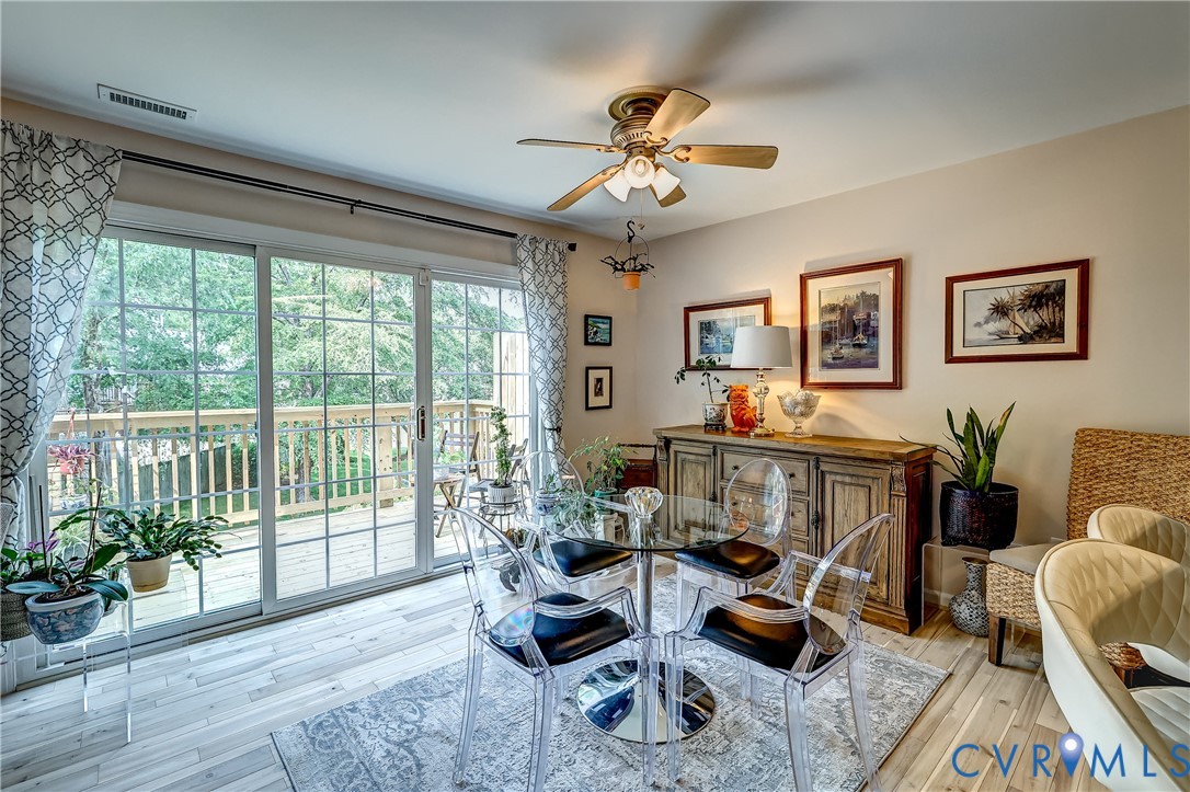 Dining room with a glass table and sliding doors opening onto a deck.