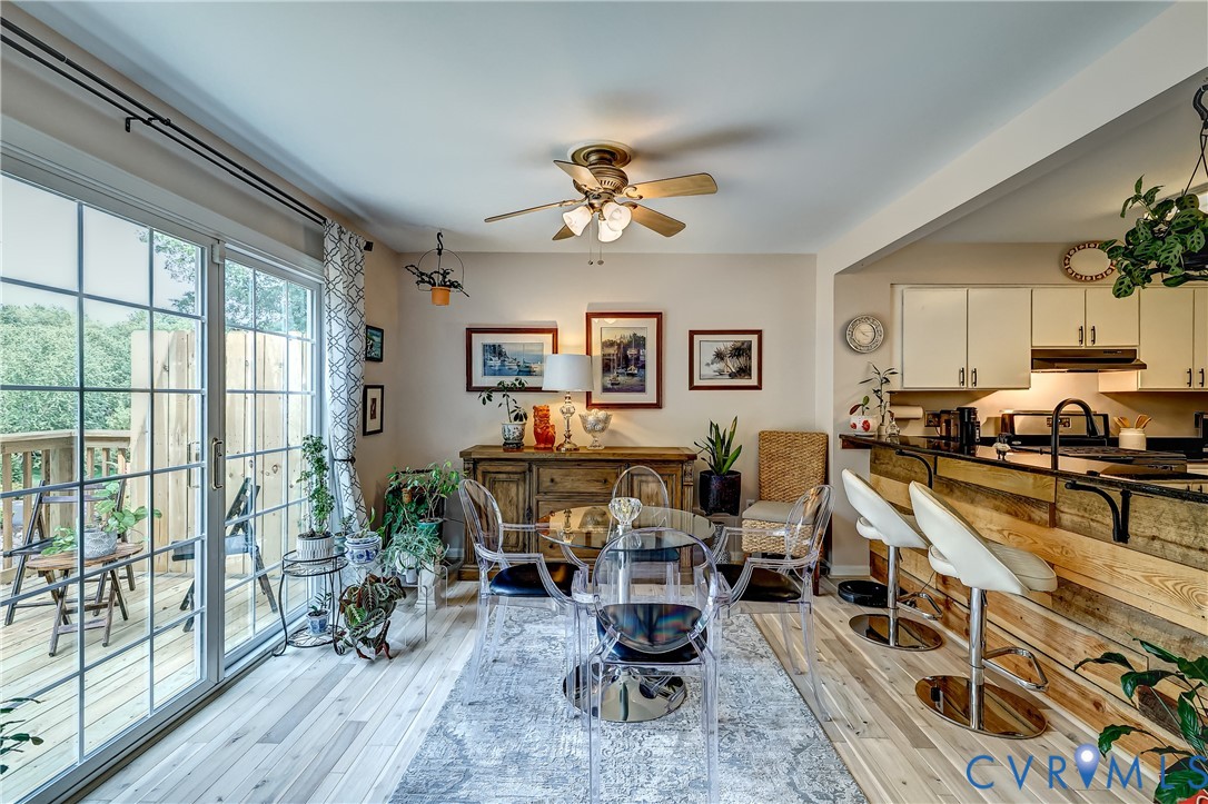 Dining area with a clear table beside the kitchen and sliding glass doors to a deck.