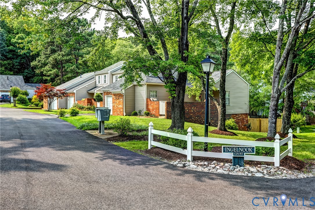 Tree-lined street of gray-sided homes with brick accents and an Ingelnook Court sign.